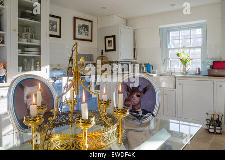 Chaise de salle à manger Meubles dans Visitorian Cory imprime autour d'une table à manger en verre surmontée cuisine avec vaisselier blanc et aga Banque D'Images