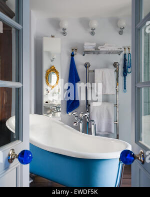 Voir à travers les doubles portes d'une salle de bains privative avec articles de bleu baignoire permanent Banque D'Images