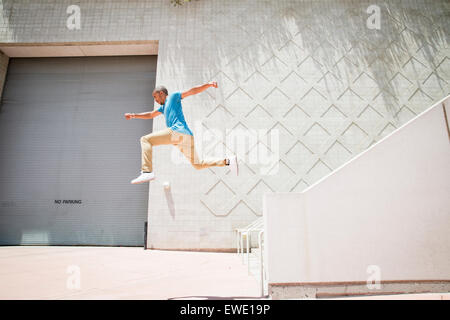 Jeune homme sautant sur un parcours d'escalier parkour Banque D'Images