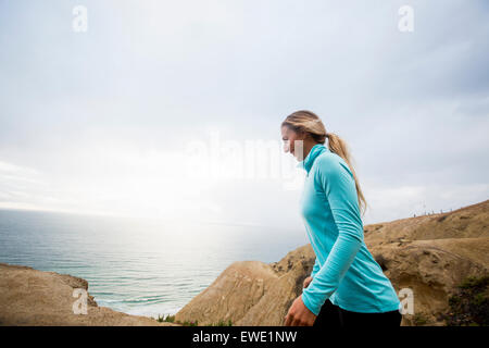 Woman jogging le long de la côte en marche sur le chemin Banque D'Images