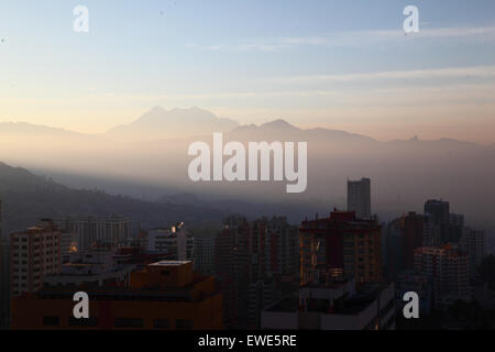 La Paz, Bolivie, 24 juin 2015. La fumée remplit les vallées de la partie inférieure de La Paz peu après le lever du soleil après la nuit de San Juan. San Juan est traditionnellement considéré comme la partie la plus froide de l'année et de nombreuses personnes en Bolivie la lumière de joie et d'artifice. Les autorités locales ont tenté de mettre fin à cette coutume dans les dernières années pour réduire la pollution supplémentaire dans la ville, mais avec un succès limité. Le pic de l'arrière-plan est l'Illimani 6439m haut Mt. Banque D'Images