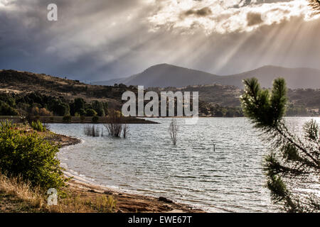 Les rayons du soleil qui brille à travers les nuages sur les collines du lac Jindabyne, Australie. Banque D'Images