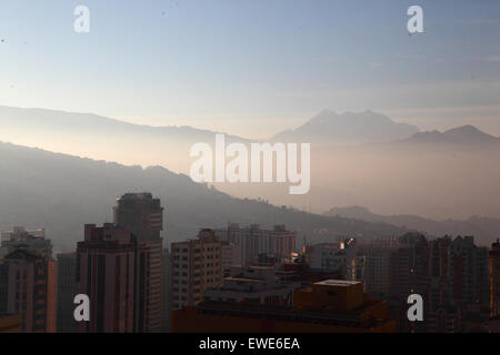 La Paz, Bolivie, 24 juin 2015. La fumée remplit les vallées de la partie inférieure de La Paz peu après le lever du soleil après la nuit de San Juan. San Juan est traditionnellement considéré comme la partie la plus froide de l'année et de nombreuses personnes en Bolivie la lumière de joie et d'artifice. Les autorités locales ont tenté de mettre fin à cette coutume dans les dernières années pour réduire la pollution supplémentaire dans la ville, mais avec un succès limité. Le pic de l'arrière-plan est l'Illimani 6439m haut Mt. Banque D'Images