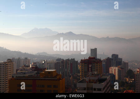 La Paz, Bolivie, 24 juin 2015. La fumée remplit les vallées de la partie inférieure de La Paz peu après le lever du soleil après la nuit de San Juan. San Juan est traditionnellement considéré comme la partie la plus froide de l'année et de nombreuses personnes en Bolivie la lumière de joie et d'artifice. Les autorités locales ont tenté de mettre fin à cette coutume dans les dernières années pour réduire la pollution supplémentaire dans la ville, mais avec un succès limité. Le pic de l'arrière-plan est l'Illimani 6439m haut Mt. Banque D'Images