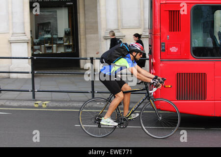 Un cycliste de dépasser un bus à impériale rouge à Londres, en Angleterre. Banque D'Images