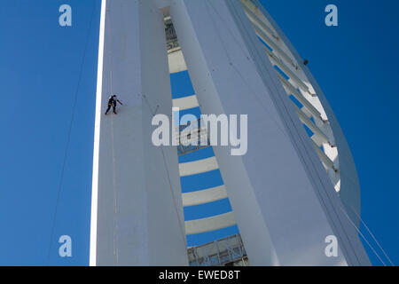 Portsmouth, Hampshire, Royaume-Uni. 24 juin 2015. Des travaux de préparation sont en cours pour le changement de nom de la tour Portsmouth Spinnaker Tower à Portsmouth. Les ouvriers en rappel ressemblent à des fourmis minuscules contre la grande structure qui doit être peint pour rebranding avec le nom de sponsor Emirates. Le plan initial était de le peindre en rouge, mais à la suite d'une pétition du public, la proposition actuelle est de le peindre en bleu et en or. Crédit : Carolyn Jenkins/Alay Live News Banque D'Images