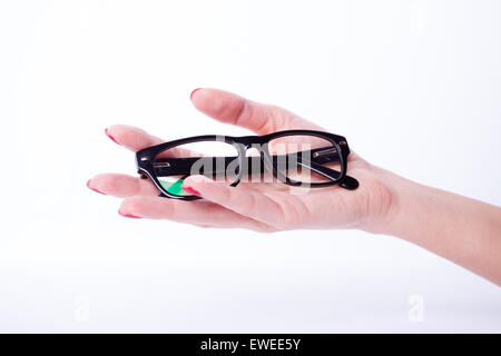 Femme mains manucure rouge lunettes noires holding Banque D'Images