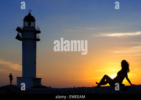 Le coucher du soleil. Jolie femme à contre-jour phare du Cap de Barbaria, à Minorque, Îles Balears. L'Espagne. Phare du Cap de Barbaria formentera road. Banque D'Images