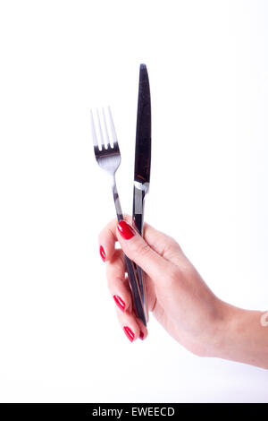 Main Femme avec manucure rouge holding knife and fork Banque D'Images