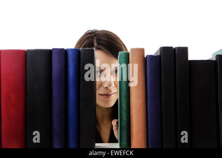 Femme à la recherche à travers les livres sur une étagère Banque D'Images