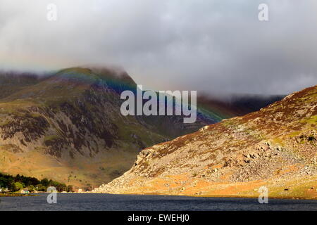 Un arc-en-ciel se lève sur Llyn Ogwen devant un nuage surmontée Foel Goch Banque D'Images