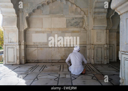 L'homme afghane en vêtements traditionnels prie en petite mosquée de marbre blanc de Shah Jahan à l'intérieur du jardin de Babur, Kaboul, Afghanistan Banque D'Images