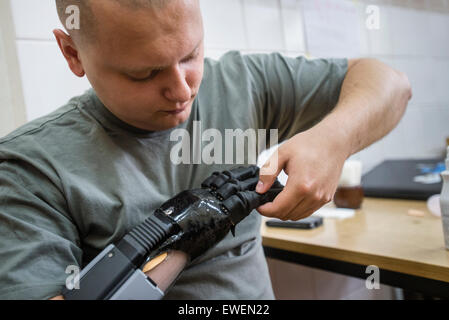 Vlad Kuznetsov, un héros à partir de la 95e brigade aéroportée, est en train de tester sa future main au cours de l'Ukraine dans le cadre du projet d'aide prothétique. Il a sauvé la vie de six collègues Lancer grenade pro-russe hors de leur véhicule blindé, mais a perdu le poignet. UPAP est projet de charité organisé par l'ukrainien et les travailleurs médicaux et les personnalités publiques pour transférer les connaissances et la réhabilitation prothétique de spécialistes américains et canadiens à leurs collègues en Ukraine. Au cours de projet cinq ukrainiens ont reçu une prothèse bionique de haute qualité, dont trois soldats ukrainiens ont perdu leurs membres dans les batailles. Kiev, Ukraine. Banque D'Images