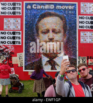 Festival de Glastonbury, Somerset, Royaume-Uni. 24 juin 2015. Comme la vie nocturne de Glastonbury se met en route un groupe de jeunes hommes dans le 'Shangri-la l'enfer" du site selfies posent pour une en face d'une peinture murale géante de David Cameron faite de milliers d'images individuelles de UK de manifestations politiques. Crédit : Tom Jura/Alamy Live News Banque D'Images