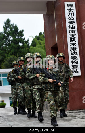 (150625) -- DEHONG, 25 juin 2015 (Xinhua) -- Zhang Liu (avant) et ses camarades de marche dans la ligne à la porte de la frontière de checkpoint dans Dai-Jingpo Mukang Dehong Préfecture autonome, le sud-ouest de la province chinoise du Yunnan, le 24 juin 2015. Né en 1995, Zhang Liu est devenu un anti-drogue soldat en poste frontière de Mukang en 2013. Grandi dans une famille aisée dans le centre de la Chine, la province du Hunan, Zhang a dit qu'être un soldat avait toujours été son rêve, qui ont poussé à rejoindre l'armée après avoir obtenu son diplôme d'école. Être un front line force anti-drogue, le poste frontière de Mukang a saisir Banque D'Images