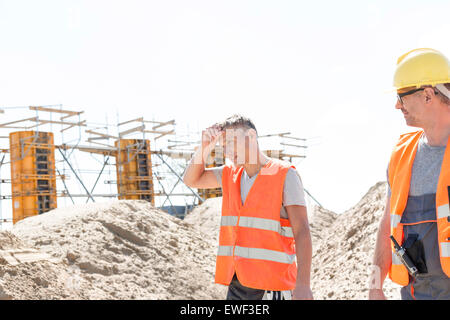 Travailleur de la construction à la collègue fatigué à la sueur d'essuyage sur le site Banque D'Images