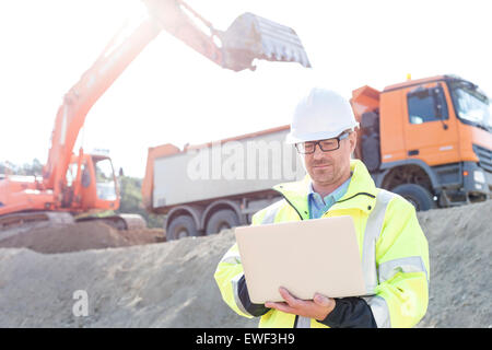 Superviseur en utilisant laptop at construction site sur sunny day Banque D'Images