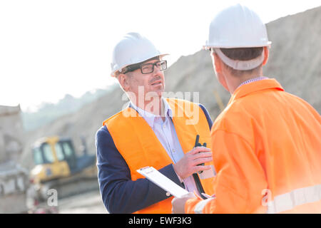 Architects discussing at construction site sur sunny day Banque D'Images