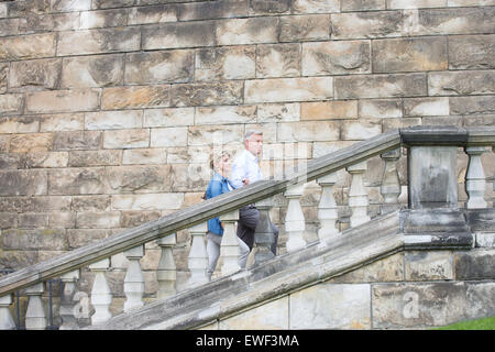 Vue latérale du couple climbing steps à l'extérieur de l'ancien bâtiment Banque D'Images