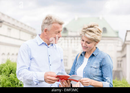 Couple d'âge moyen à l'extérieur du bâtiment guide de lecture Banque D'Images