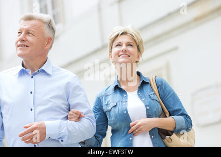 Smiling middle-aged couple bras dessus bras dessous en plein air Banque D'Images