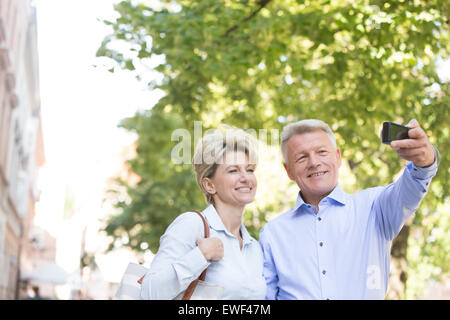 Happy middle-aged couple en tenant l'extérieur selfies Banque D'Images