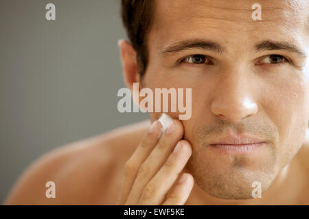 Close-up of young man applying shaving cream Banque D'Images