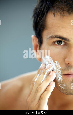 Close-up of young man applying shaving cream Banque D'Images