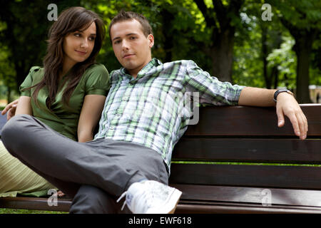 Young couple sitting on bench Banque D'Images