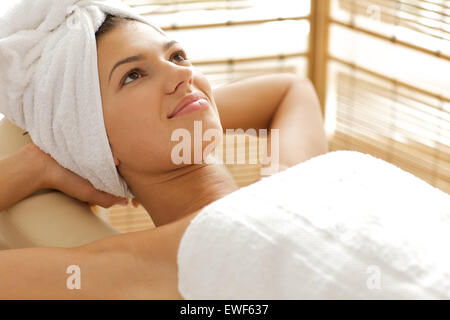 Close-up of young woman relaxing on massage table with hands behind head Banque D'Images