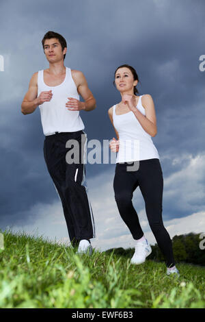 Jeune couple exercising in park Banque D'Images