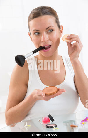 WOMAN PUTTING ON MAKE-UP Banque D'Images