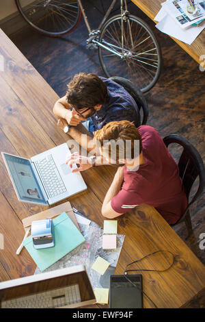 Les hommes d'affaires occasionnels using laptop in office Banque D'Images