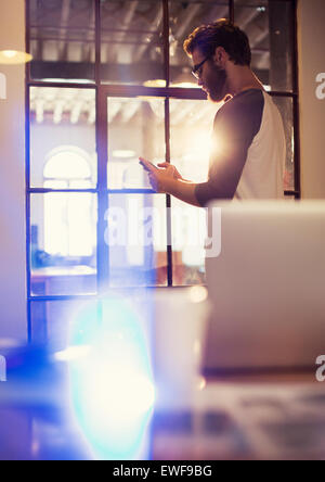 Businessman texting with cell phone in office Banque D'Images