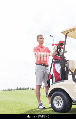 Homme d'âge moyen par article au panier golf course Banque D'Images