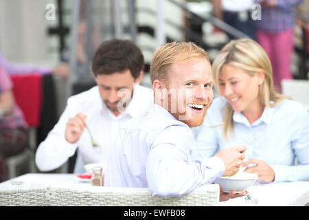 Portrait of happy young avec nos collègues de l'outdoor restaurant Banque D'Images