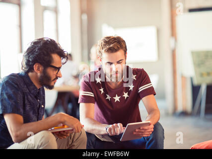 Les hommes d'affaires occasionnels using digital tablet in office Banque D'Images