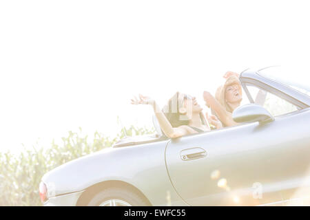 Cheerful female friends enjoying road trip in convertible sur sunny day Banque D'Images