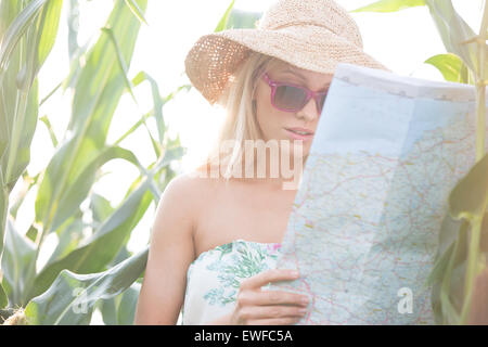 Femme lisant la carte tout en se tenant au milieu de plantes en plein air Banque D'Images