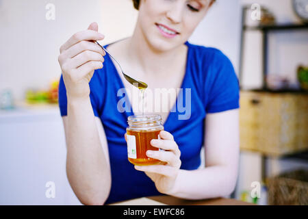 Femme MANGEANT LE MIEL Banque D'Images