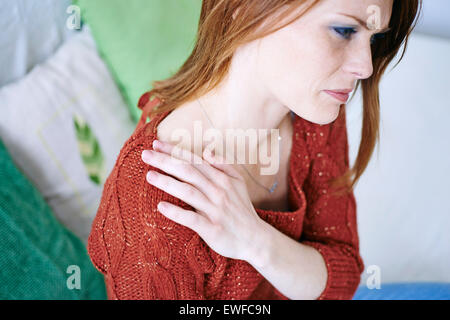 Femme AVEC LA DOULEUR DE L'ÉPAULE Banque D'Images