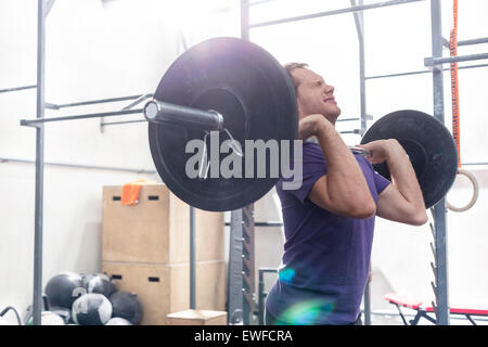 Homme confiant barbell levage crossfit en salle de sport Banque D'Images