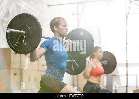 L'homme et la femme dans le barbell levage crossfit gym Banque D'Images