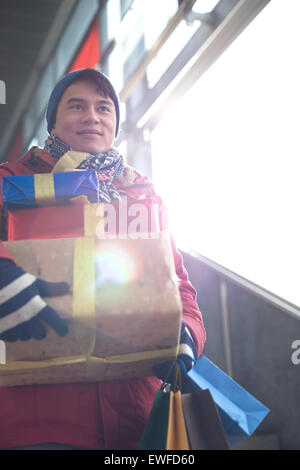 Low angle view of man holding gifts by window Banque D'Images