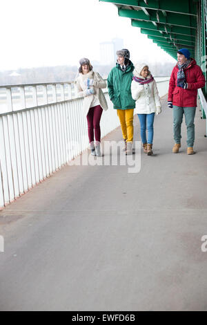 Amis multiethnique marche sur sentier en hiver Banque D'Images