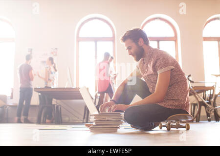 Businessman working at laptop de skateboard Banque D'Images