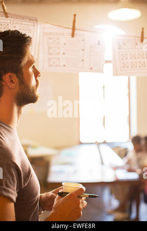 Pensive businessman hanging revue diagrammes de l'office de tourisme Banque D'Images