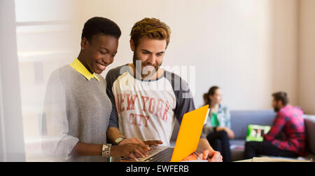 Casual business people sharing laptop in office Banque D'Images