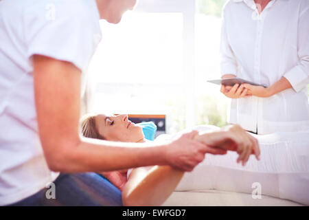 Masseuse massaging woman's hand Banque D'Images