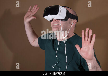 Homme portant un ZEISS de réalité virtuelle VR VR lunettes en plastique avec support pour Samsung Galaxy S5 smartphone Android et in-ear Banque D'Images